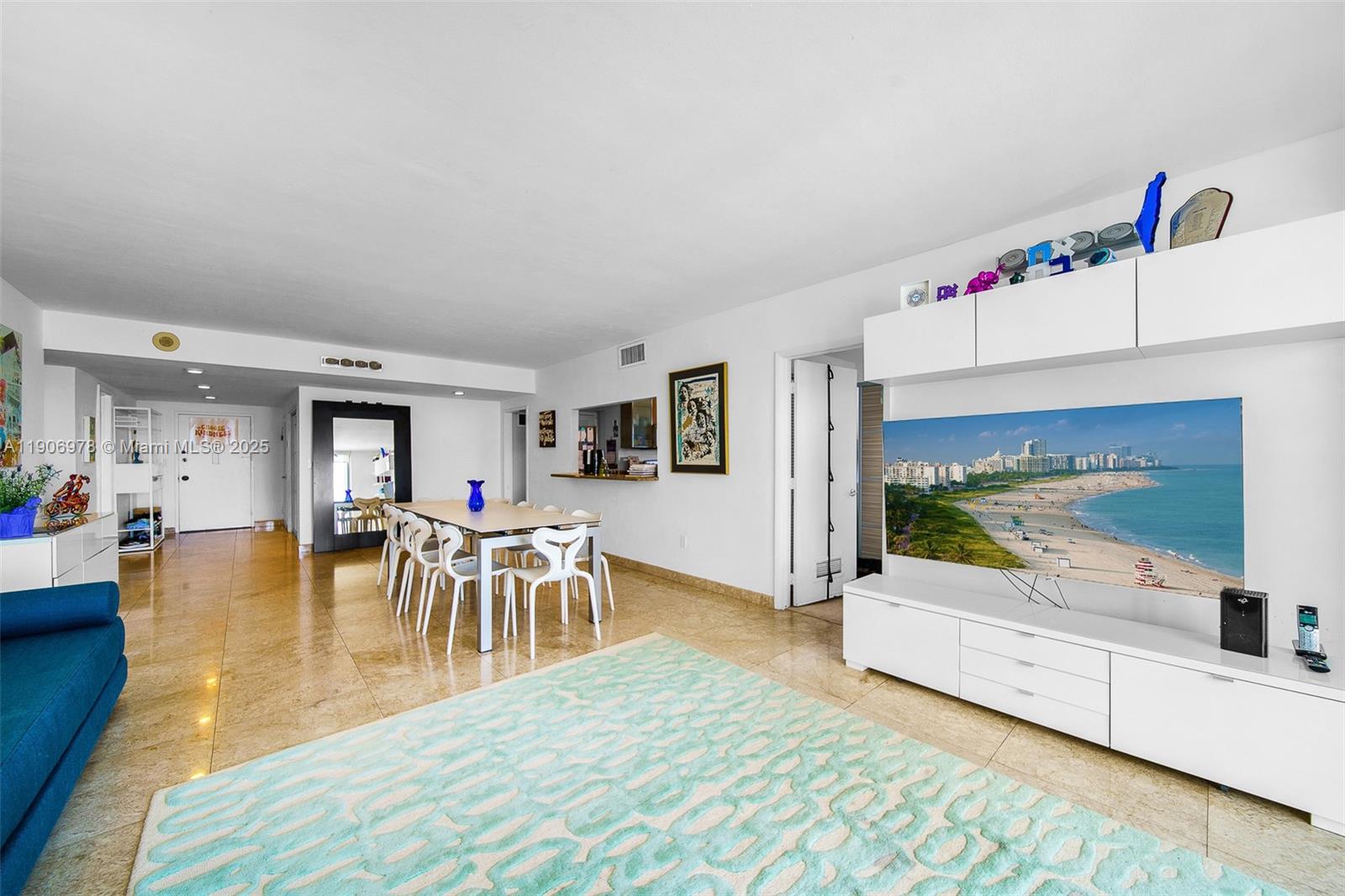 5825 Collins Avenue, Unit 10G Miami Beach, FL 33140 - Photo 22 of 51 a living room with furniture and a flat screen tv