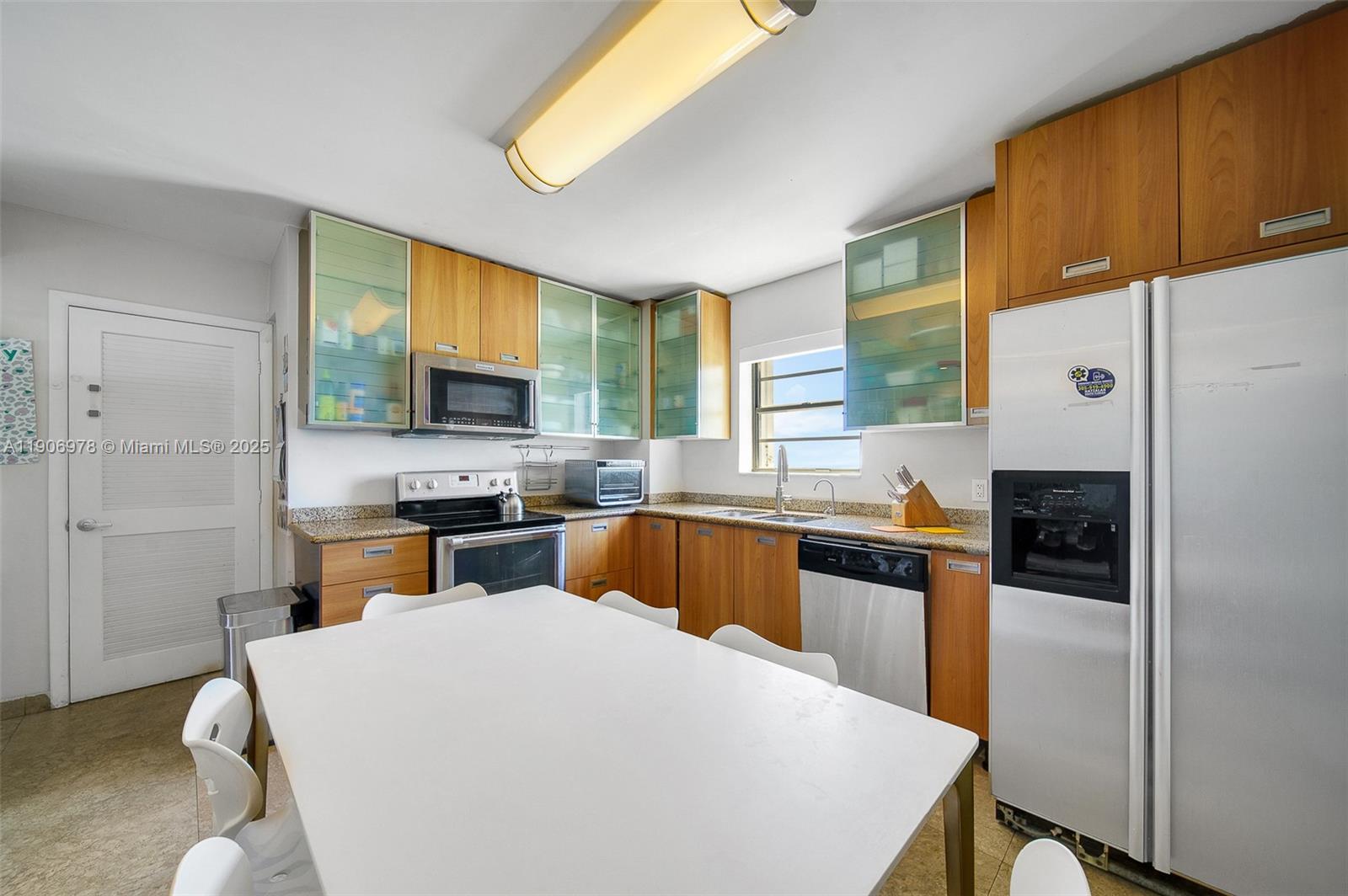 5825 Collins Avenue, Unit 10G Miami Beach, FL 33140 - Photo 23 of 51 a kitchen with a refrigerator a stove a sink dishwasher and microwave with wooden floor