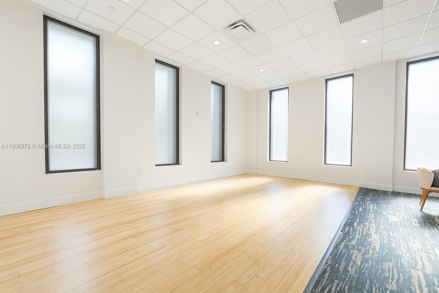 5825 Collins Avenue, Unit 10G Miami Beach, FL 33140 - Photo 31 of 51 an empty room with wooden floor and windows