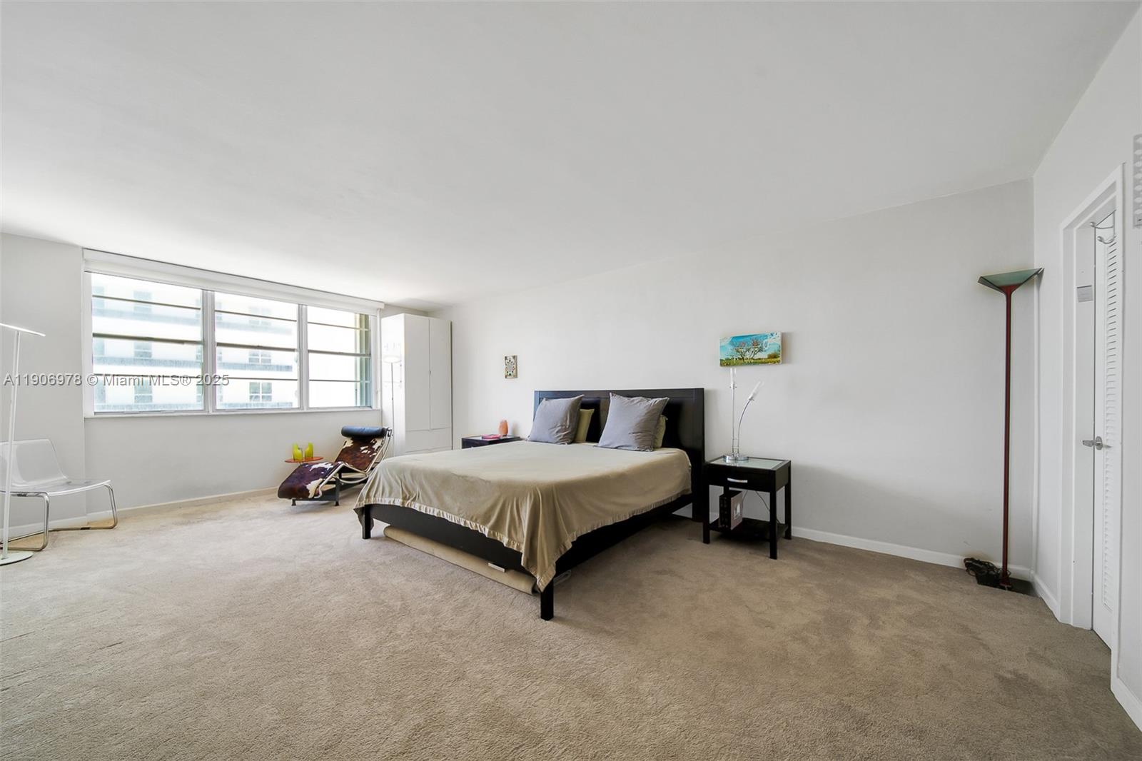 5825 Collins Avenue, Unit 10G Miami Beach, FL 33140 - Photo 34 of 51 a spacious bedroom with a bed and a window