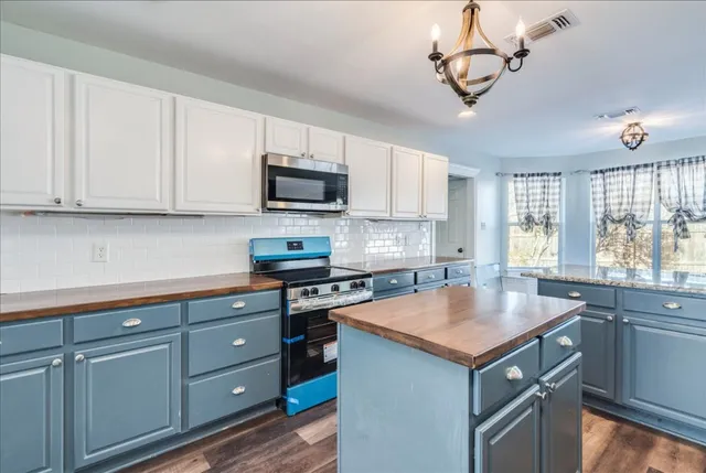 a kitchen with cabinets appliances a sink and a window