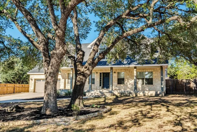 a view of a house with a tree in the yard