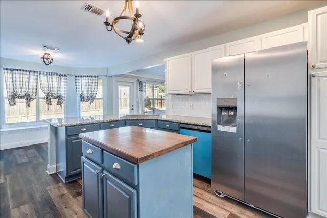 a kitchen with stainless steel appliances granite countertop a sink a refrigerator and a window