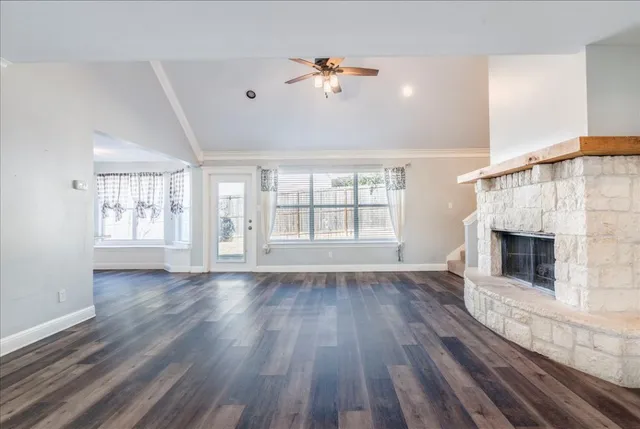 wooden floor fireplace and windows in an empty room