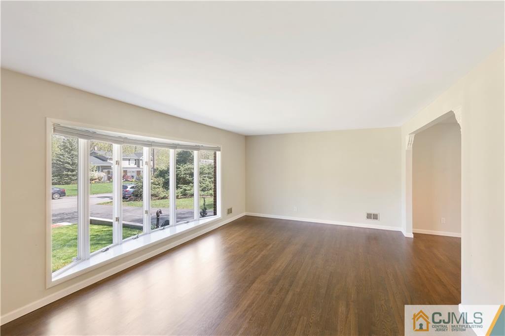 144 Devon Road Colonia, NJ 07067 - Photo 3 of 24 an empty room with wooden floor and windows