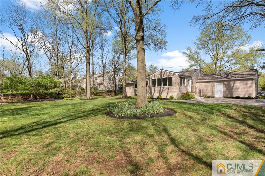 144 Devon Road Colonia, NJ 07067 - Photo 22 of 24 a view of a white house next to a yard with big trees