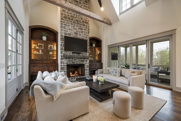 a living room with furniture kitchen view and a chandelier