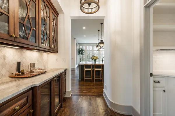 a view of a hallway with wooden floor and stairs