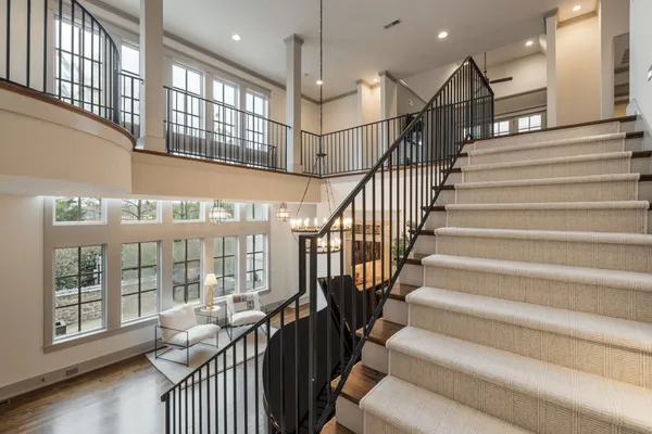 a view of a white house next to a yard with large trees