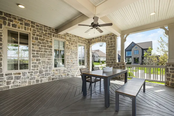 a view of a patio with a table chairs and wooden floor