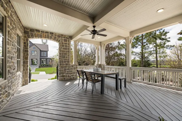 a living room with couches a dining table with chandelier