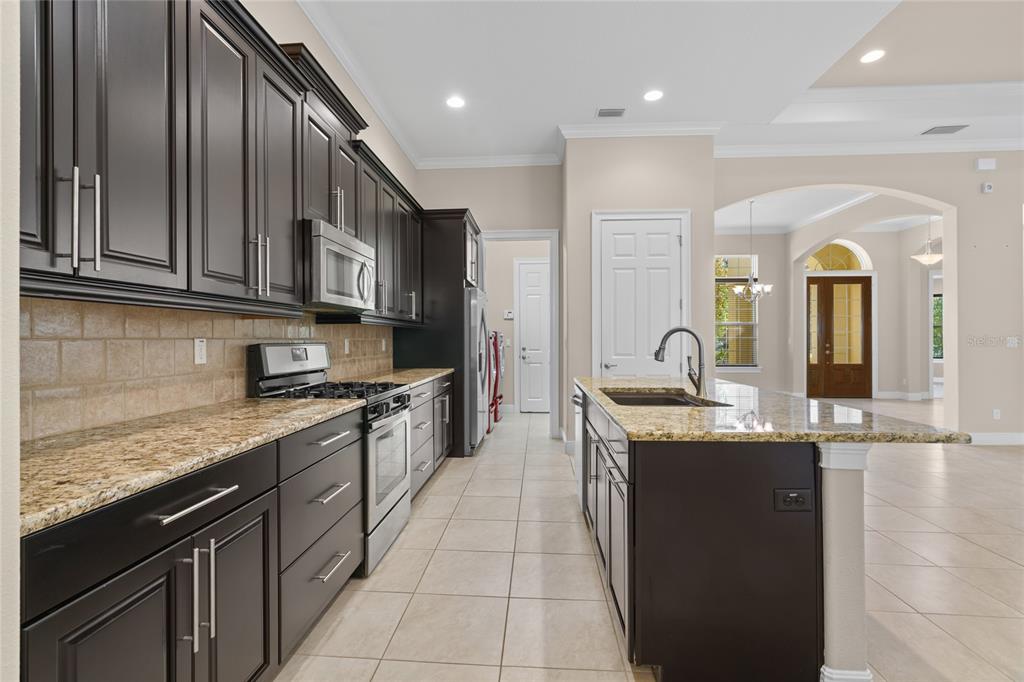 4117 Southeast 21st Street Ocala, FL 34471 - Photo 12 of 38 a kitchen with stainless steel appliances granite countertop a sink stove and cabinets