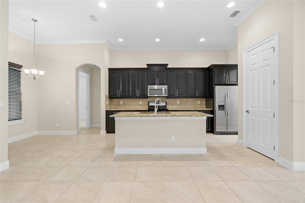 4117 Southeast 21st Street Ocala, FL 34471 - Photo 10 of 38 a large white kitchen with a sink a window and stainless steel appliances
