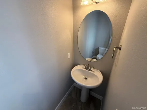 a bathroom with a granite countertop sink a mirror and shower