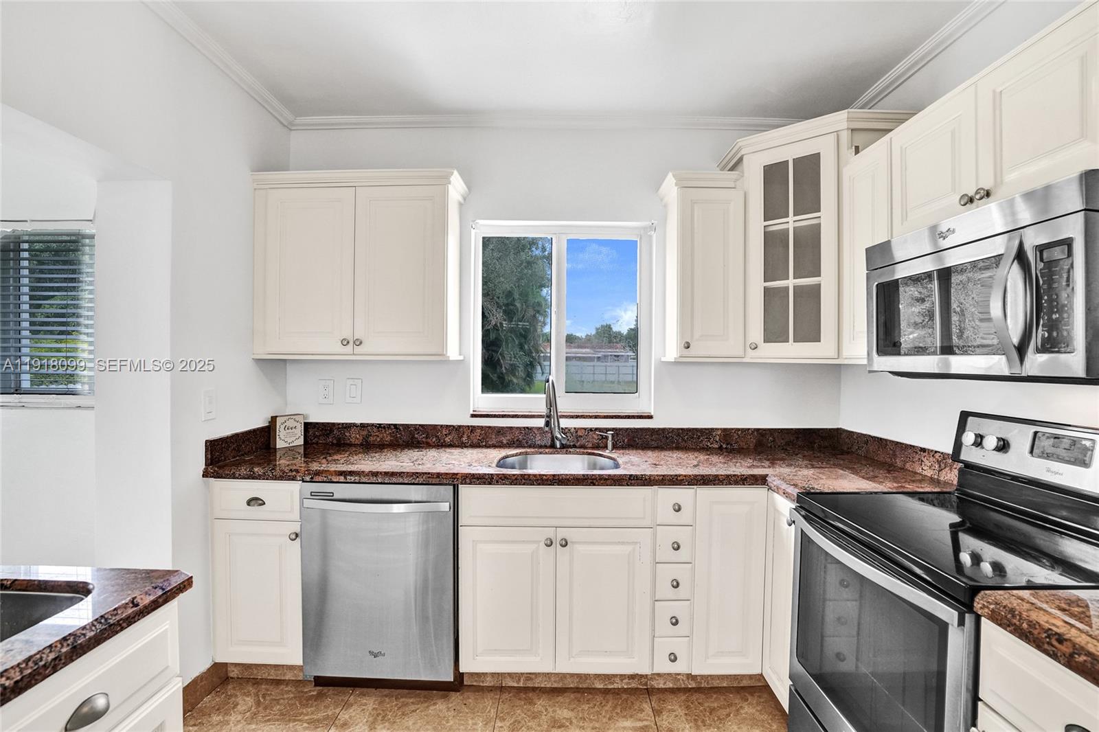 5801 Southwest 20th Street Miami, FL 33155 - Photo 13 of 40 a kitchen with stainless steel appliances granite countertop a sink stove and cabinets