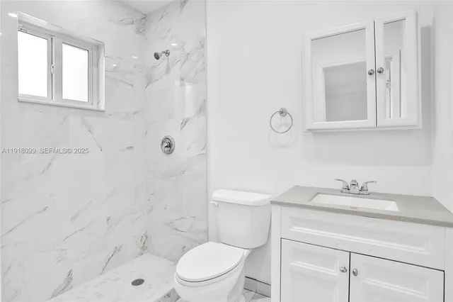 a bathroom with a sink toilet and a mirror