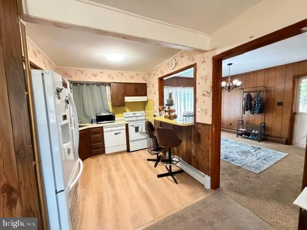 a kitchen with sink a refrigerator and chairs