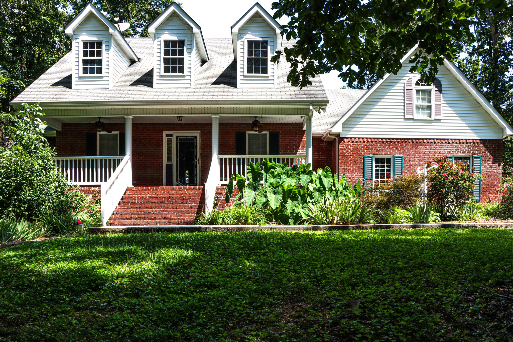 a front view of a house with a garden