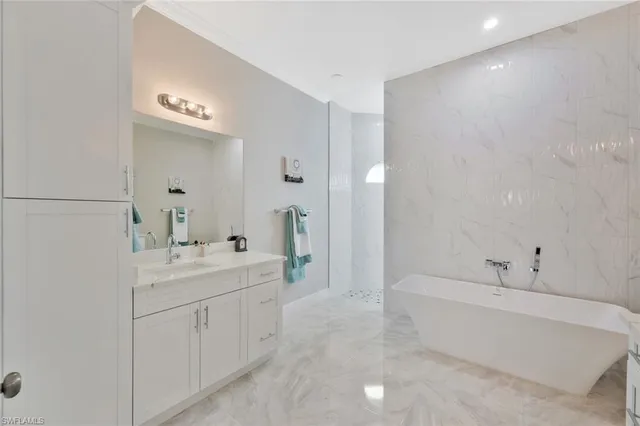 a spacious bathroom with a bathtub sink and mirror