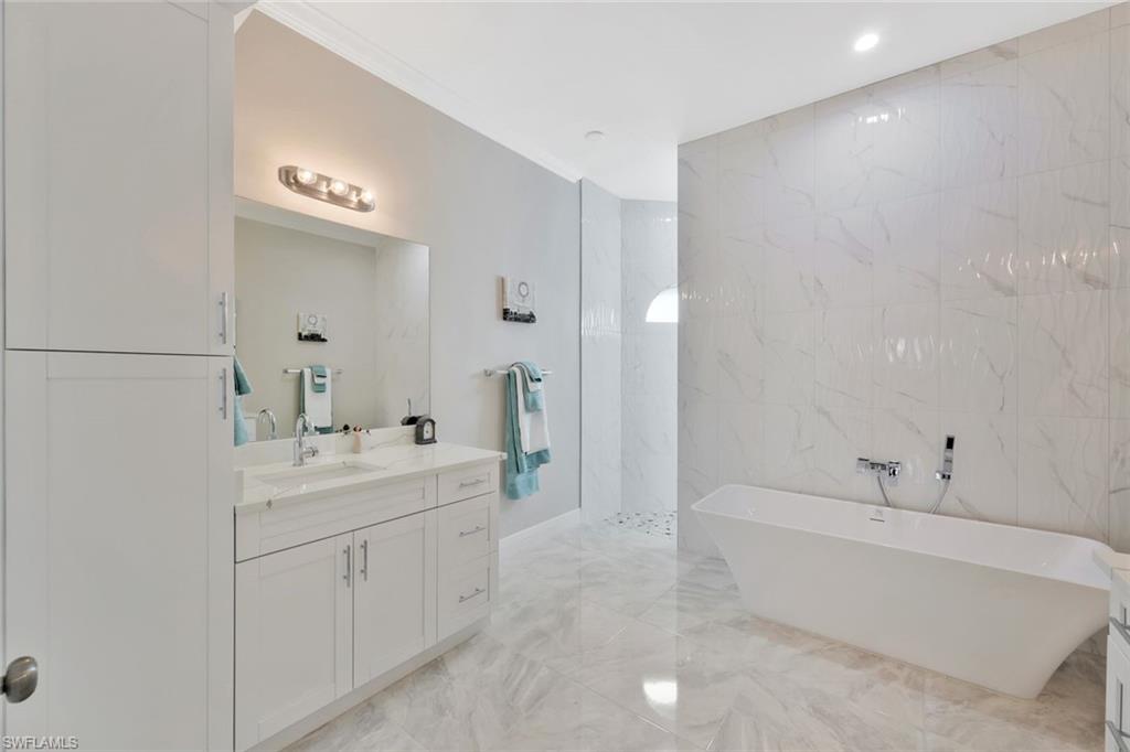 589 12th Avenue Northwest Naples, FL 34120 - Photo 12 of 28 a spacious bathroom with a bathtub sink and mirror