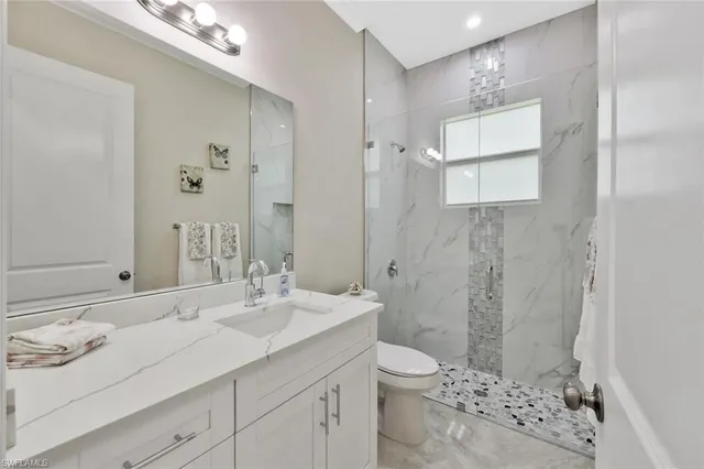a bathroom with a sink toilet double vanity and shower