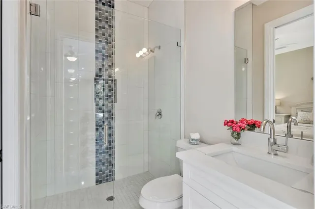 a bathroom with a sink vanity mirror and toilet