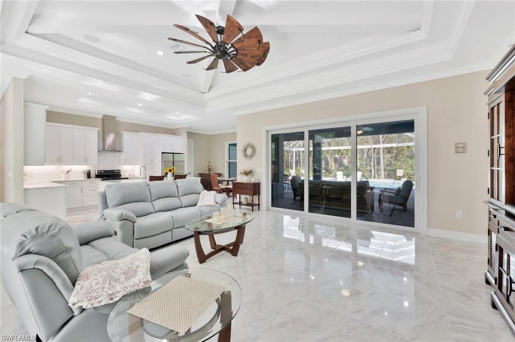 589 12th Avenue Northwest Naples, FL 34120 - Photo 3 of 28 a living room with furniture a chandelier and a large window
