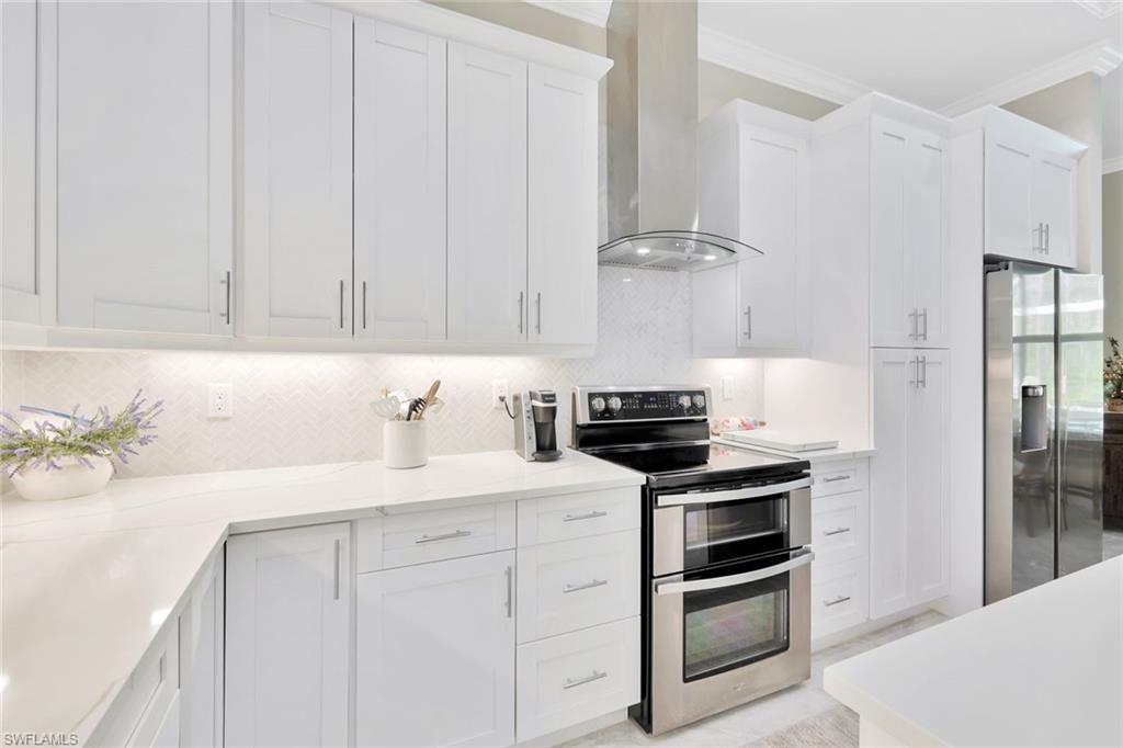 589 12th Avenue Northwest Naples, FL 34120 - Photo 6 of 28 a kitchen with white cabinets and appliances