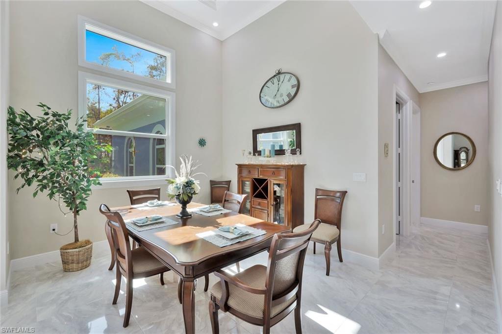 589 12th Avenue Northwest Naples, FL 34120 - Photo 9 of 28 a dining room with furniture a rug and a potted plant