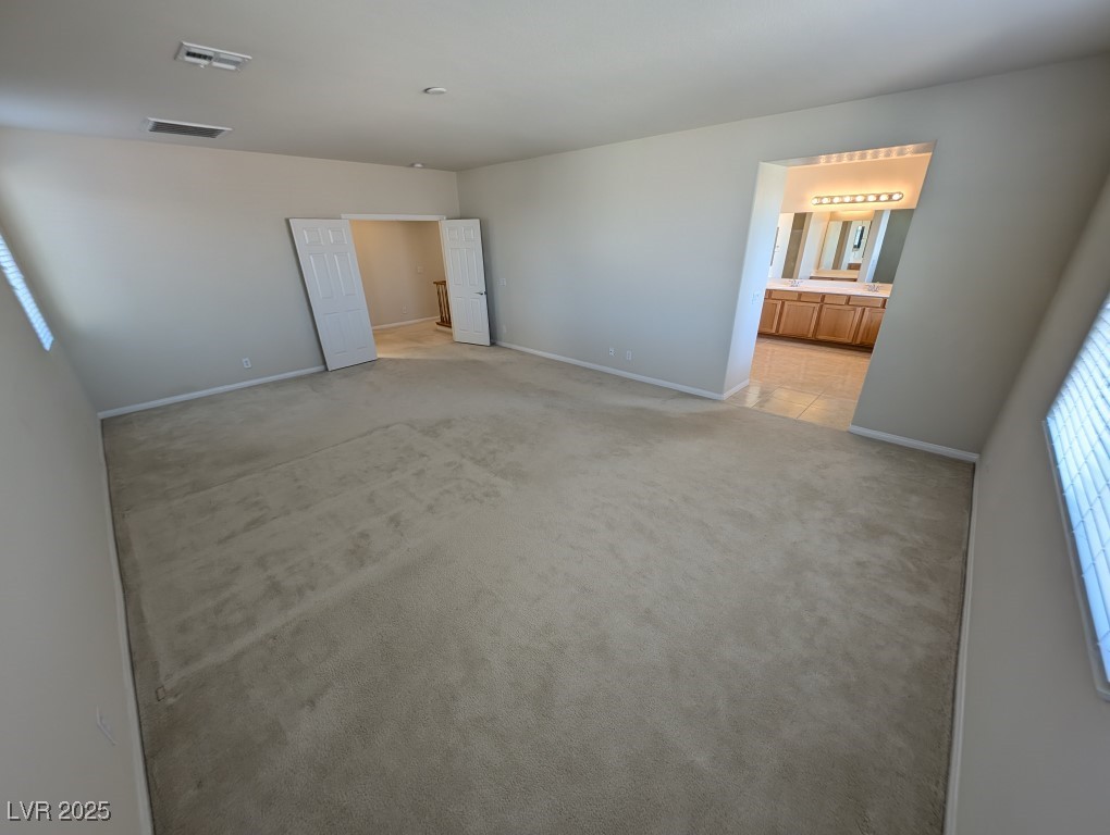 62 Augusta Course Avenue Las Vegas, NV 89148 - Photo 11 of 26 Unfurnished bedroom featuring light carpet and connected bathroom