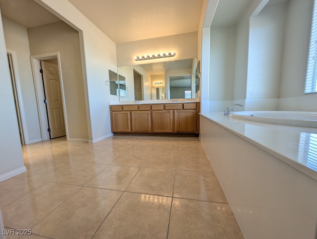 62 Augusta Course Avenue Las Vegas, NV 89148 - Photo 12 of 26 Full bathroom featuring a garden tub, double vanity, and light tile patterned floors
