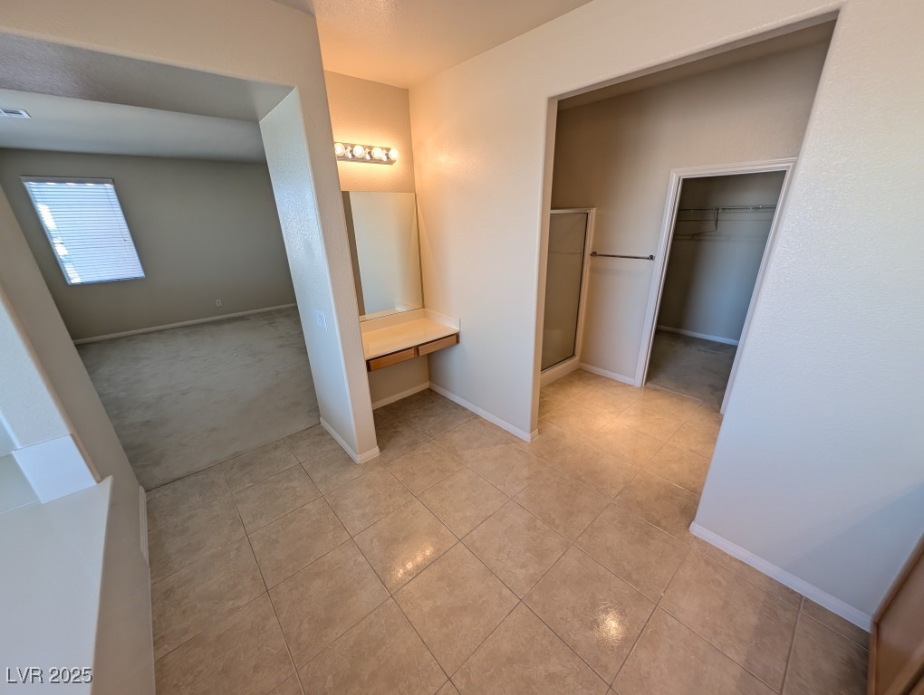 62 Augusta Course Avenue Las Vegas, NV 89148 - Photo 13 of 26 Bathroom featuring a spacious closet, a shower stall, tile patterned flooring, carpet floors, and vanity