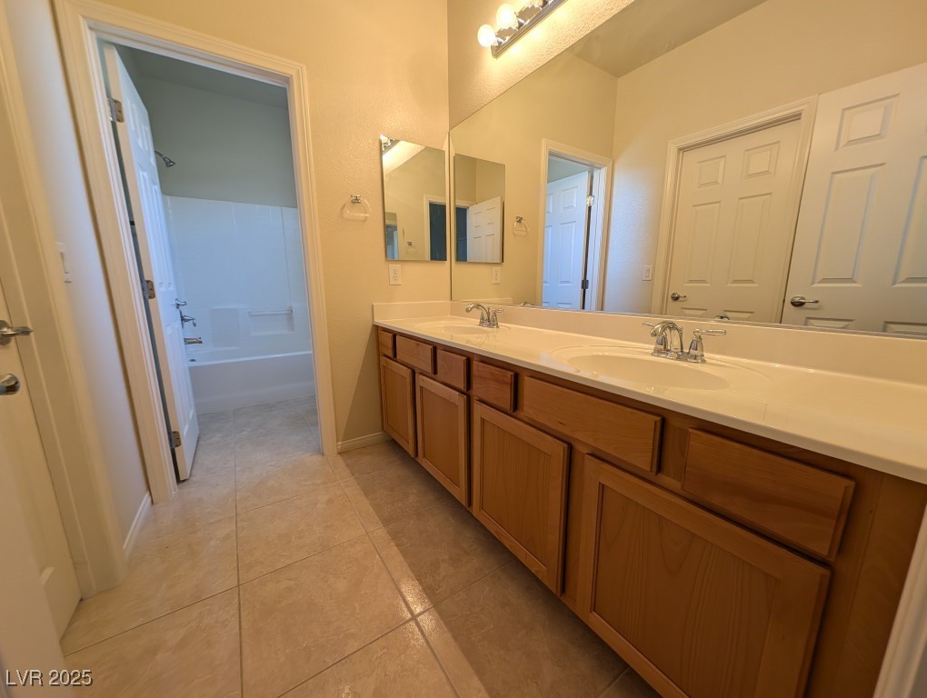 62 Augusta Course Avenue Las Vegas, NV 89148 - Photo 18 of 26 Full bath with double vanity, light tile patterned floors, and shower / bath combination