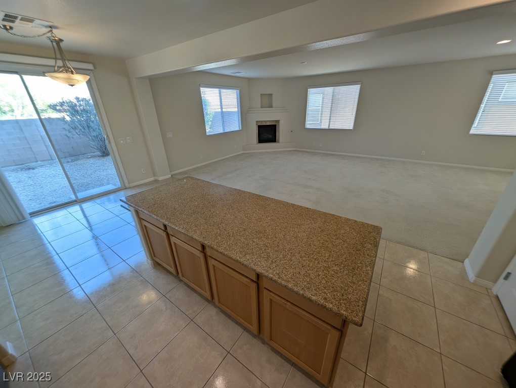 62 Augusta Course Avenue Las Vegas, NV 89148 - Photo 7 of 26 Unfurnished living room with light carpet, light tile patterned floors, and a fireplace with raised hearth