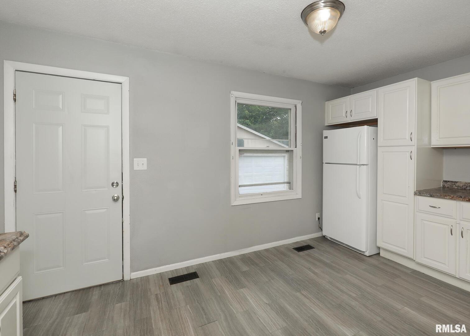 1310 Calvin Street Davenport, IA 52804 - Photo 6 of 39 an empty room with wooden floor cabinet and windows