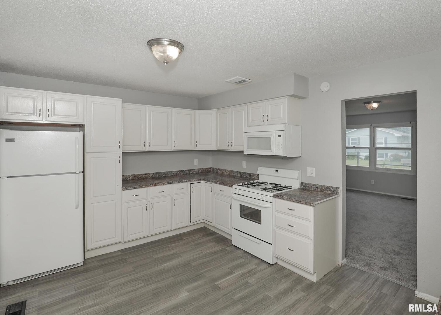1310 Calvin Street Davenport, IA 52804 - Photo 7 of 39 a kitchen with granite countertop white cabinets and white appliances