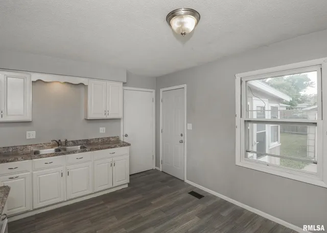 a view of a kitchen with a sink dishwasher and wooden floor