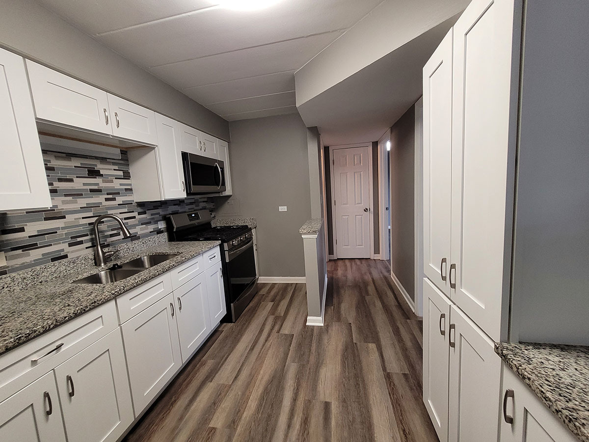 2820 Dundee Road, Unit 2B Northbrook, IL 60062 - Photo 2 of 16 a kitchen with granite countertop a sink stove and cabinets