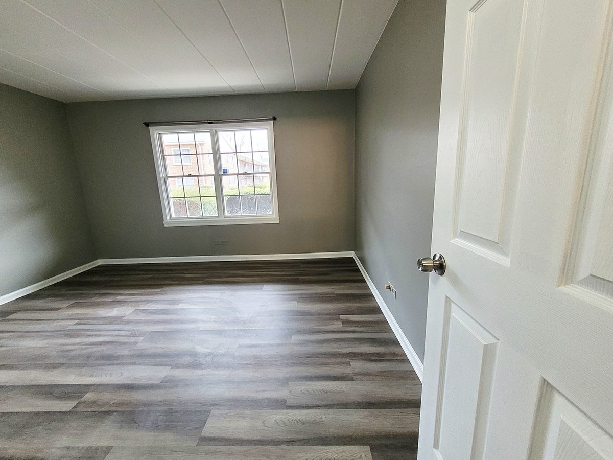 2820 Dundee Road, Unit 2B Northbrook, IL 60062 - Photo 9 of 16 a view of an empty room with wooden floor and a window