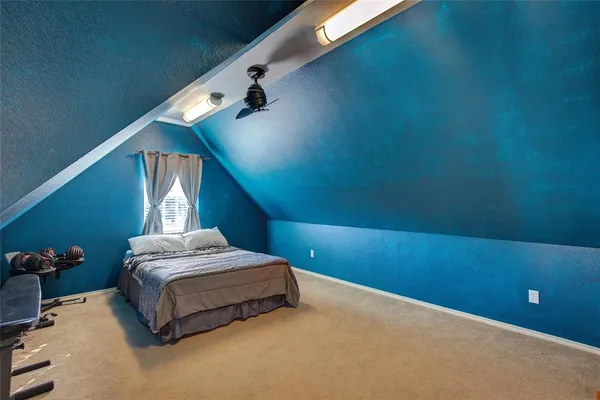 a spacious bedroom with a bed and a potted plant