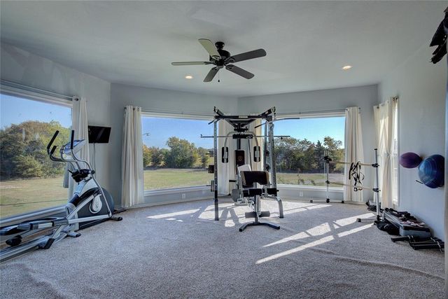 a view of a room with gym equipment and floor to ceiling window