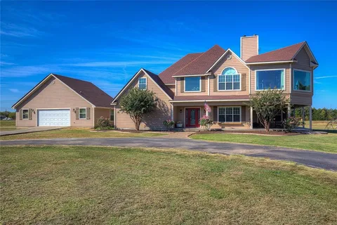 a view of house with garden and tall trees