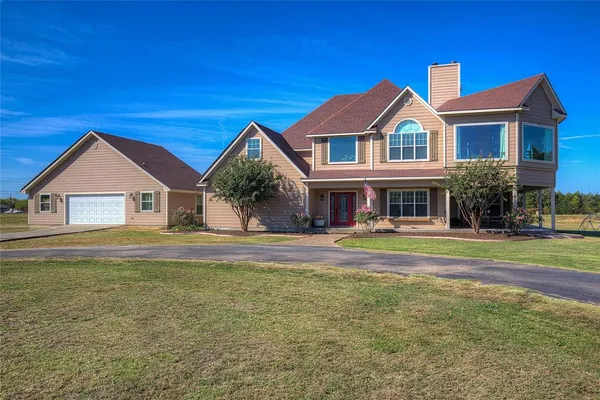 a view of house with garden and tall trees