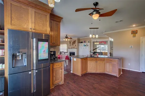 a kitchen with stainless steel appliances granite countertop a refrigerator a stove and a wooden floors