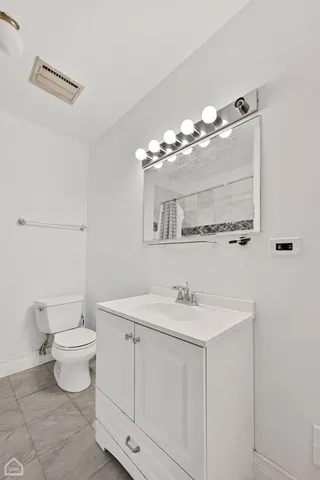 an empty room with wooden floor cabinet and windows