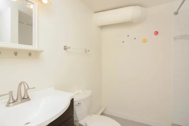 a bathroom with a sink a toilet and shower