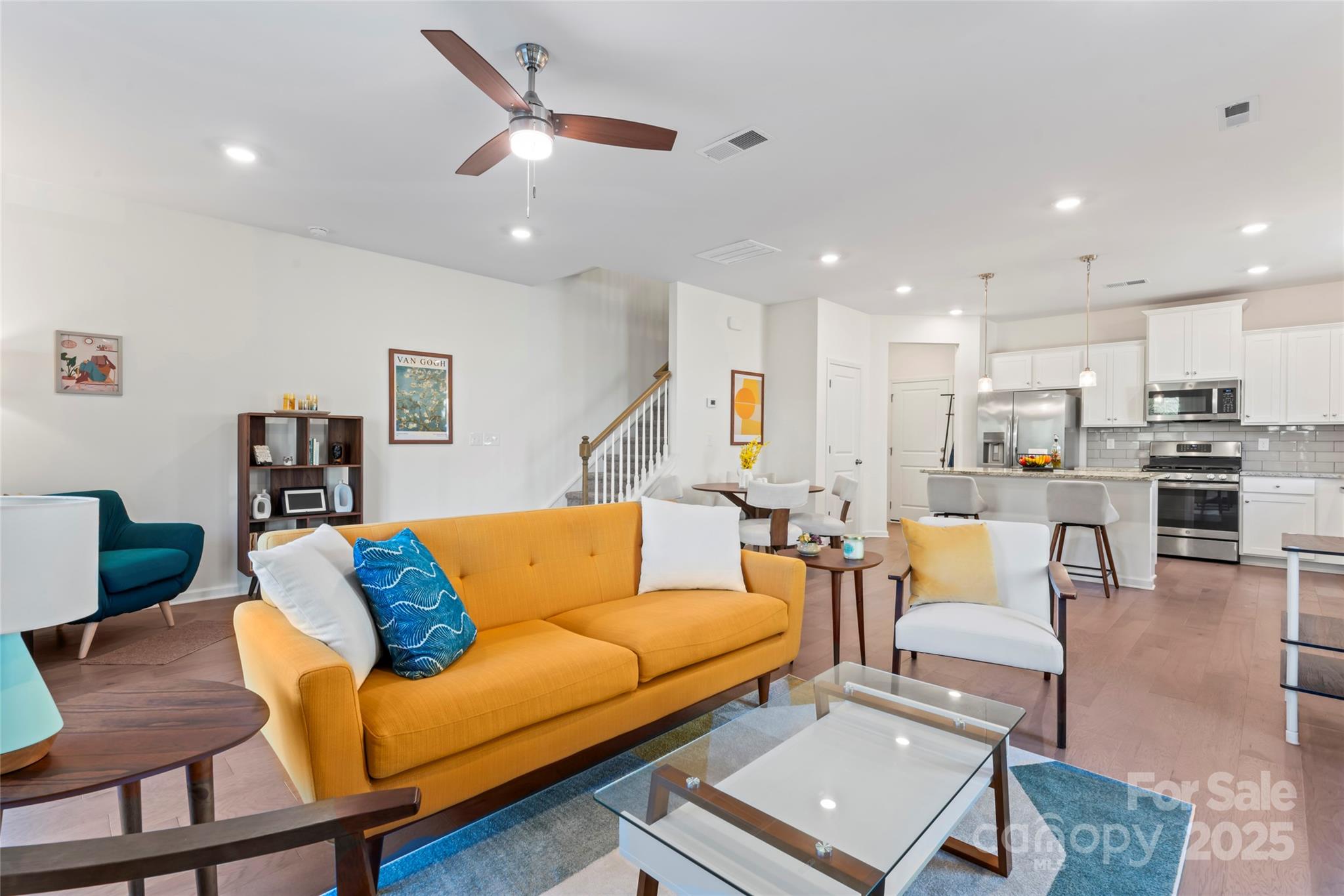 a living room with furniture and a view of kitchen
