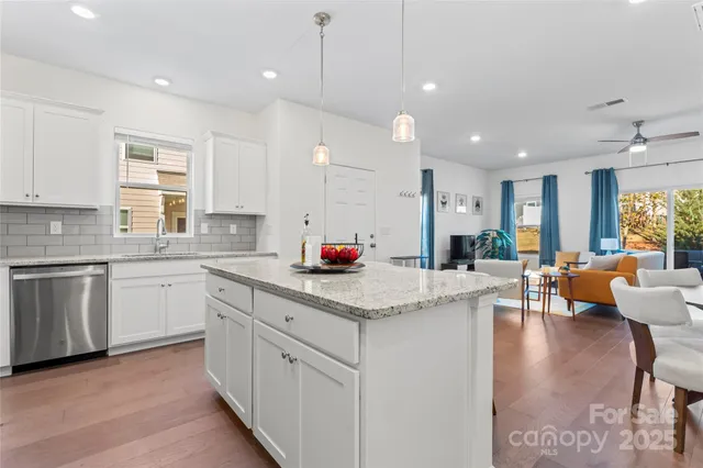 a kitchen with stainless steel appliances a stove a sink island and a refrigerator