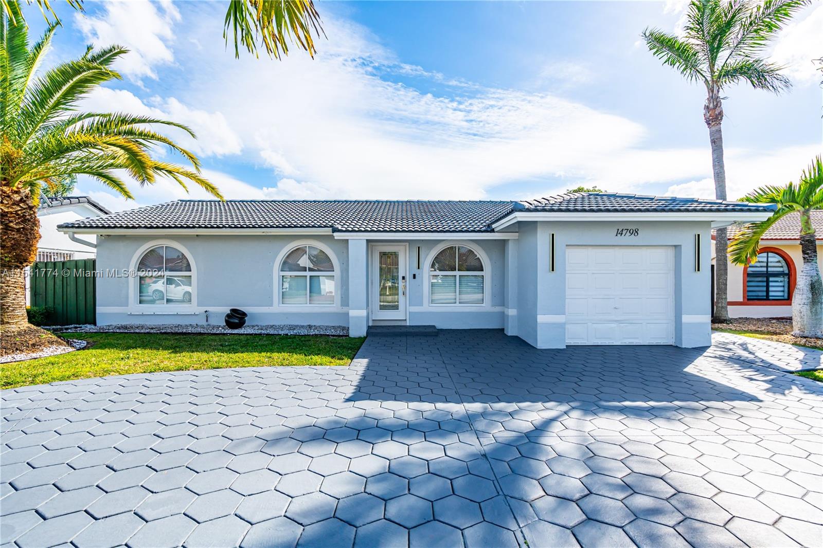 a front view of a house with swimming pool and porch with furniture
