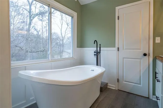 a white bath tub sitting in a bathroom next to a window